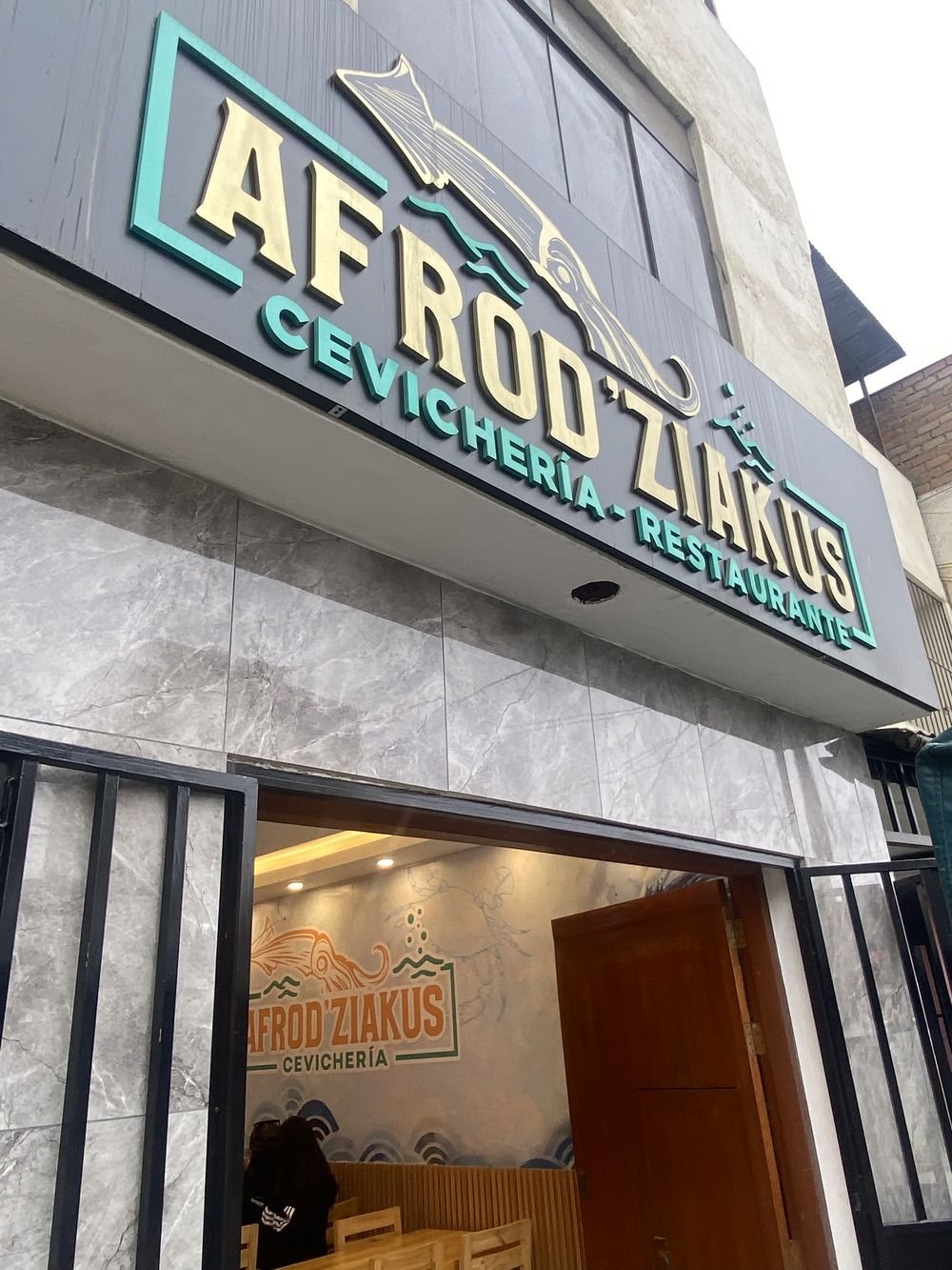 Fachada de Cevichería Afrodiziakus con su letrero turquesa y oro